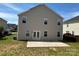 The rear of the house with a gray facade and backyard including a concrete patio at 6614 Burkwood Ct, Harrisburg, NC 28075