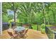 Deck with a table, four chairs, a grill, and stairs leading down to a verdant backyard at 6722 Elmstone Dr, Charlotte, NC 28277