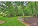 Backyard features mature trees, manicured landscaping, and a lush lawn at 6722 Elmstone Dr, Charlotte, NC 28277