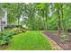 Spacious backyard with lush greenery, mature trees, and a wooden deck for outdoor enjoyment at 6722 Elmstone Dr, Charlotte, NC 28277