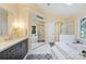 Bright bathroom featuring a soaking tub, glass enclosed shower and gray vanity at 6722 Elmstone Dr, Charlotte, NC 28277