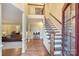 Bright foyer showcasing hardwood floors, staircase with wood and iron railing, and view into living room at 6722 Elmstone Dr, Charlotte, NC 28277
