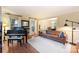 Cozy living room with hardwood floors, a grand piano, and comfortable leather seating at 6722 Elmstone Dr, Charlotte, NC 28277