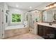 Bathroom featuring a soaking tub, glass-enclosed shower, and double vanity at 7006 Nesbit Rd, Waxhaw, NC 28173