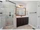The bathroom includes a framed mirror, a vanity with dark cabinets, and a tiled shower with glass door at 7006 Nesbit Rd, Waxhaw, NC 28173