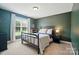 The bedroom is designed with a modern, dark metal bed frame and a matching blue nightstand, with carpet at 7006 Nesbit Rd, Waxhaw, NC 28173