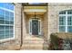 Charming front entrance with brick steps, decorative wreath, and inviting covered porch at 7006 Nesbit Rd, Waxhaw, NC 28173
