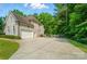 Spacious three-car garage with an extended driveway surrounded by a lush, wooded landscape at 7006 Nesbit Rd, Waxhaw, NC 28173