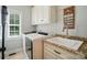 A laundry room features a modern white washer and sink with granite countertops, plus storage cabinets at 7006 Nesbit Rd, Waxhaw, NC 28173