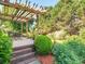 Outdoor patio with a wooden pergola, dining set, and lush landscaping, perfect for entertaining or relaxing at 725 Old State Sw St, Concord, NC 28027