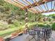 Covered patio with metal table and chairs, string lights, and lush landscaping offer ideal outdoor entertaining at 725 Old State Sw St, Concord, NC 28027