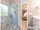 A bathroom featuring a tiled shower with glass enclosure, bench, and a doorway leading to the bedroom at 725 Old State Sw St, Concord, NC 28027