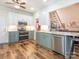Modern kitchen features two-tone cabinetry, stainless steel appliances, and hardwood floors, opening to staircase at 725 Old State Sw St, Concord, NC 28027