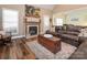 This living room features hardwood floors, a fireplace, and access to the kitchen and has a seating area at 725 Old State Sw St, Concord, NC 28027
