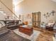A spacious living room with hardwood floors, a large brown leather sectional sofa, and decor at 725 Old State Sw St, Concord, NC 28027