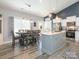 Modern kitchen with stainless steel appliances, gray island, and dining area at 805 Brookmont Ave, Salisbury, NC 28146