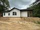 Side view of a home with white siding and a black roof on a cloudy day at 807 S Bostian St, China Grove, NC 28023