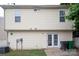 Image shows back exterior with white siding and door that leads to a small patio space at 8432 Spirea Ct, Charlotte, NC 28215