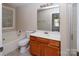 Bathroom features wood vanity, mirror, toilet and shower-tub combination with window at 8432 Spirea Ct, Charlotte, NC 28215