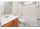 Bright bathroom with a vanity, toilet and shower-tub combination with tile surround at 8432 Spirea Ct, Charlotte, NC 28215