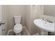 Compact bathroom features a modern toilet and a pedestal sink with chrome fixtures at 8432 Spirea Ct, Charlotte, NC 28215