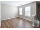 Bedroom featuring wood floors, two windows, and a neutral paint scheme at 8432 Spirea Ct, Charlotte, NC 28215