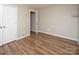 Bedroom with wood-look floors, closet and open doorway to the rest of the house at 8432 Spirea Ct, Charlotte, NC 28215
