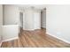 Open bedroom area showcasing wood-look floors, neutral paint, and entry to other bedroom at 8432 Spirea Ct, Charlotte, NC 28215