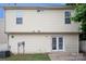 Back exterior of home with light yellow siding featuring a glass door and an air conditioning unit at 8432 Spirea Ct, Charlotte, NC 28215