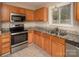 Well-lit kitchen showcasing stainless steel appliances, granite countertops, and tile flooring at 8432 Spirea Ct, Charlotte, NC 28215