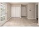 Bright living room with tile floor, neutral paint, a double door leading to outside, and foyer at 8432 Spirea Ct, Charlotte, NC 28215