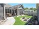Landscaped backyard featuring manicured artificial turf, patio, and a decorative water feature at 9062 Treetop Nw Way, Concord, NC 28027
