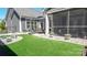 Charming backyard featuring artificial turf, stone accents, and a screened-in porch for relaxing outdoors at 9062 Treetop Nw Way, Concord, NC 28027