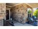 Charming porch with stone facade, stylish seating, and a welcoming entrance at 9062 Treetop Nw Way, Concord, NC 28027