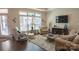 Inviting living room featuring plush seating, a decorative rug, and ample natural light from large windows at 9062 Treetop Nw Way, Concord, NC 28027