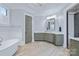 Stylish bathroom with a bathtub, marble countertop, and sleek gray cabinetry at 9807 Aristides Dr, Waxhaw, NC 28173