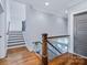 Upstairs hallway with hardwood flooring, stairs, and a gray accent wall at 9807 Aristides Dr, Waxhaw, NC 28173