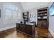 Office features built-in bookshelves, a large arched window, and hardwood flooring at 9807 Aristides Dr, Waxhaw, NC 28173