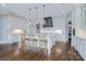 Bright open kitchen featuring a large island with seating, white cabinets, and modern pendant lighting at 9807 Aristides Dr, Waxhaw, NC 28173