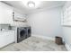Spacious laundry room with modern washer and dryer, granite countertop, and ample storage at 9807 Aristides Dr, Waxhaw, NC 28173