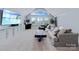 Bright living room with large windows, neutral tones, a vintage arcade game, and a modern entertainment center at 9807 Aristides Dr, Waxhaw, NC 28173