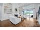 Bright living room with built-in shelving, a cozy fireplace, and sliding doors to the outdoor space at 9807 Aristides Dr, Waxhaw, NC 28173