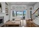 Bright living room with hardwood floors, large windows to the backyard pool, fireplace and built-in shelving at 9807 Aristides Dr, Waxhaw, NC 28173