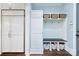 Mudroom with custom built-ins, storage cubbies, and a bench, next to a built-in refrigerator at 9807 Aristides Dr, Waxhaw, NC 28173