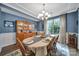 Cozy dining room with blue walls, a wooden hutch, and a beautifully set table beneath an elegant chandelier at 998 Emory Ln, Fort Mill, SC 29708