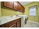 Well-lit laundry room features a sink, washer, dryer, and plenty of cabinet space for storage at 998 Emory Ln, Fort Mill, SC 29708