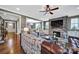 Open living room featuring a stone fireplace, mounted TV, leather sofas, and view into the dining area at 998 Emory Ln, Fort Mill, SC 29708