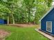 This serene backyard offers lush green grass and privacy surrounded by mature trees at 10736 Spruce Mountain Rd, Charlotte, NC 28214