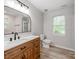 Bathroom with a wood vanity, a large mirror, and a window that provides natural light at 10736 Spruce Mountain Rd, Charlotte, NC 28214