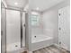 Bathroom features a bathtub and shower with glass door plus a small window at 10736 Spruce Mountain Rd, Charlotte, NC 28214